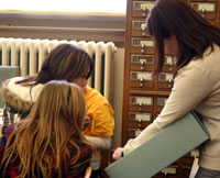 Graduate student Amy Jones shows ancient Asian artifacts to Smithton Middle School students