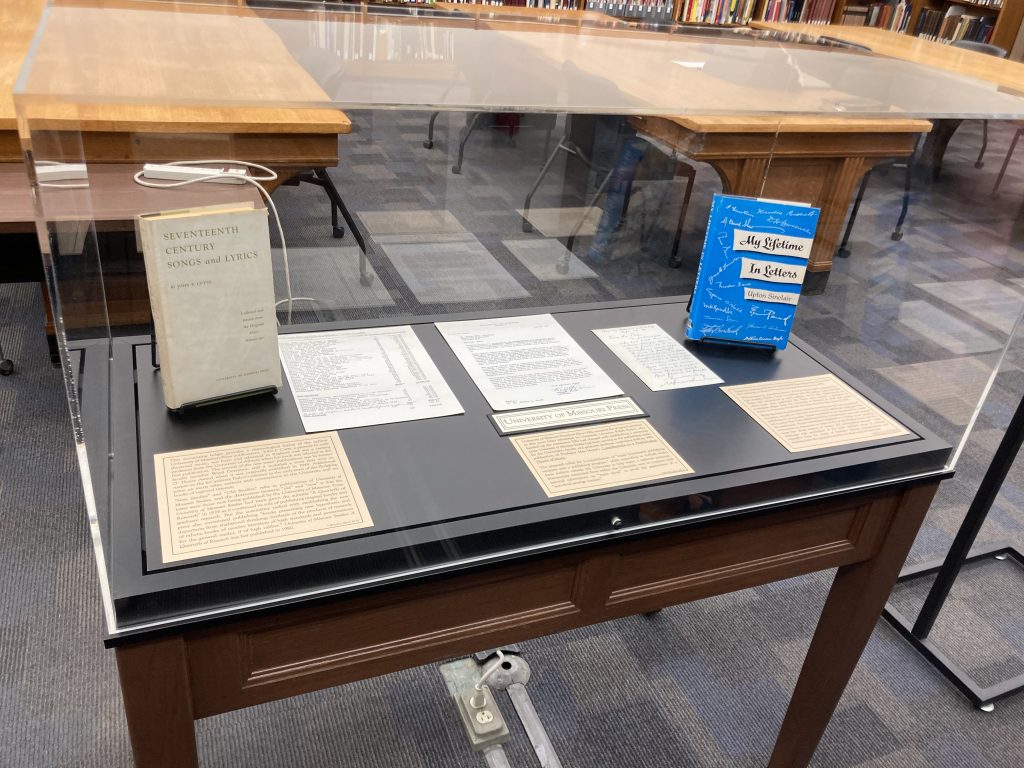 A display case with letters and books.